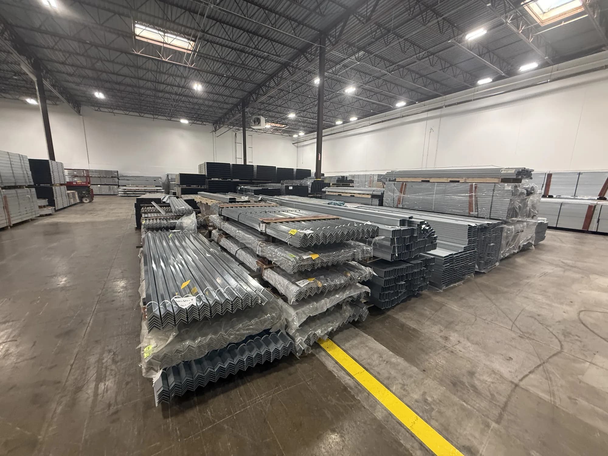 Bundles of steel framing staged on the warehouse floor